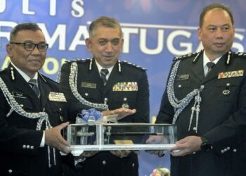 RUSLAN Khalid (kiri), menyerahkan tongkat kuasa kepada Ahmad Dzaffir (kanan) sambil diperhatikan oleh Azri pada majlis serah terima tugas Ketua Polis Negeri Sembilan di Seremban hari ini.-UTUSAN/MOHD. SHAHJEHAN MAAMIN.