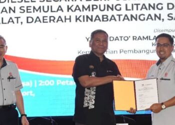 -RAMLAN Harun menyerahkan dokumen projek lampu jalan kampung kepada Mohd. Yaakob Jaafar di Kota Kinabalu hari ini.