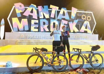AHNUAR Salleh (kanan) bersama adiknya, Mad Ithnin bergambar di Pantai Merdeka, Kedah sempena ‘Charity Ride Around The Peninsula’ baru-baru ini.