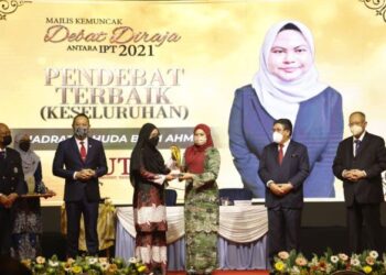 NORAINI Ahmad (tengah) menyampaikan trofi kepada pendebat terbaik keseluruhan, Nadratul Huda Ahmad di Putrajaya semalam. – UTUSAN/AMREE AHMAD