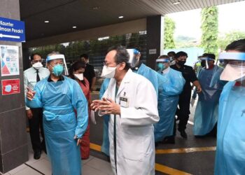 MUHYIDDIN Yassin (kiri) mendengar taklimat sewaktu melawat Bahagian Kecemasan serta Jabatan Forensik Hospital Tengku Ampuan Rahimah (HTAR), Klang, hari ini.