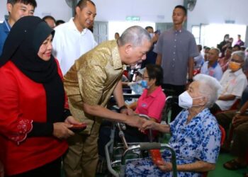 FADILLAH Yusof ketika menyantuni warga emas OKU yang bakal menyambut perayaan Tahun Baharu Cina di Jalan Sungai Tengah, Matang di sini hari ini.