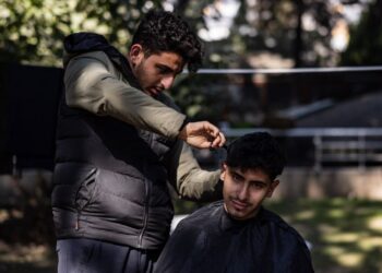 MOHAMMED al-Hamo menggunting rambut abangnya, Sobhi di kem mangsa gempa bumi di Turkiye.-AFP