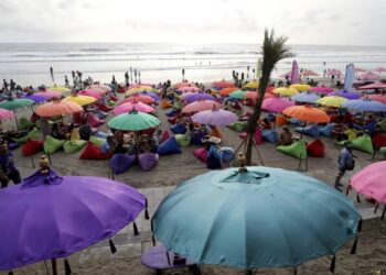 PELANCONG berkumpul menikmati keindahan pantai Kuta di Bali.-AP
