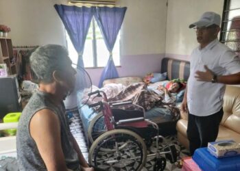 SELAMAT Takim (kanan) berbual dengan Abdul Rahman Ahmad semasa menziarahi Zulkifli Ahmad yang terlantar akibat serangan angin ahmar di Bandar Maharani, Muar, Johor.