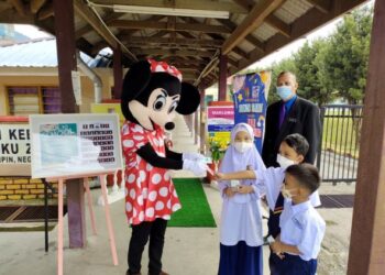 SELAIN disambut oleh maskot Minnie Mouse, murid-murid di SK Tengku Zainun di sini juga diberikan tisu basah sebagai langkah pencegahan jangkitan Covid-19 dalam kalangan mereka.-UTUSAN/NOR AINNA HAMZAH.