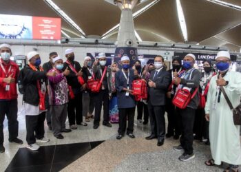 WEE Jeck Seng (tiga kanan) menyampaikan beg umrah kepada jemaah pada Majlis Lambaian Umrah Jemaah Tanjung Piai di KLIA, Sepang, Selangor. - UTUSAN/FAISOL MUSTAFA