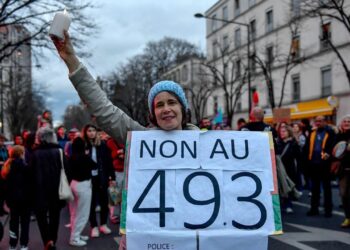 SEORANG penunjuk perasaan memegang sepanduk menolak penggunaan artikel 49.3 dalam Perlembagaan Perancis ketika menyertai protes di Paris.-AFP