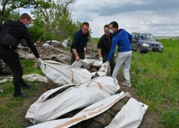 PENDUDUK tempatan membantu pasukan forensik polis Ukraine membawa mayat yang dipercayai tentera Russia di luar perkampungan Mala Rogan, berhampiran Kharkiv. - AFP