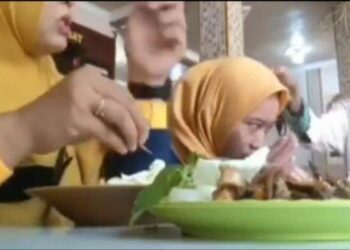 TANGKAP layar video yang menunjukkan peminta sedekah menolak kepala seorang wanita sedang makan di restoran di Probolinggo, Jawa Timur. - AGENSI