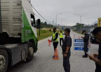 ANGGOTA penguatkuasaan KPDNHEP Gua Musang bersama dengan Jabatan Pengangkutan Jalan (JPJ) melakukan sekatan jalan raya di Stesen Timbang Jabatan Pengangkutan Jalan (JPJ), Tanah Putih, Gua Musang, Kelantan semalam. - IHSAN KPDNHEP