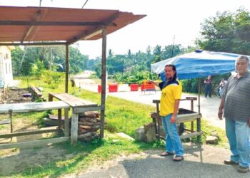 MOHD. Zubir Mohd. Esa (kiri) bersama Abdul Rashid Mashrom menunjukkan gerai jualan lemangnya yang kini sunyi sejak jalan utama Repah-Kuala Pilah ditutup di Tampin, Negeri Sembilan. - UTUSAN/NOR AINNA HAMZAH