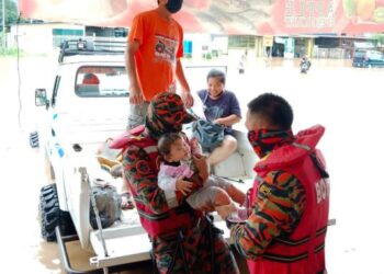 Pasukan bomba membantu memindahkan mangsa terperangkap dalam banjir kilat yang berlaku di Manggatal, Kota Kinabalu pagi tadi.-IHSAN Bomba