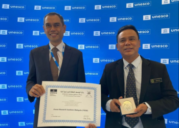 ISMAIL Parlan (kanan) menunjukkan plak Hadiah Sultan Qaboos 2021 yang diterima FRIM pada Persidangan Agung UNESCO di Paris. – Foto ihsan FRIM
