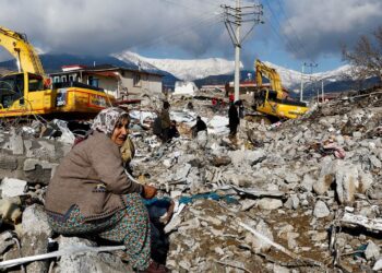 SEORANG wanita duduk di tengah-tengah runtuhan dan kerosakan di Gaziantep. -CNN