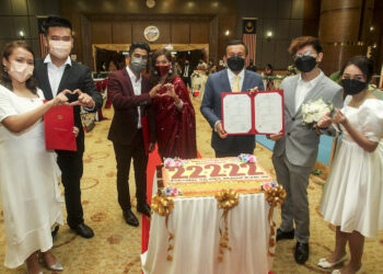 KETUA Pengarah Jabatan Pendaftaran Negara, Datuk Ruslin Jusoh (tiga dari kanan) menyerahkan sijil
perkahwinan kepada pasangan Sakda Duangdean Poon Nam, 29, dan isteri, Arisa Ah Tid, 26, di
hadapan kek dihiasi dengan nombor 22 Februari 2022 di Putrajaya semalam. - UTUSAN/FAISOL
MUSTAFA