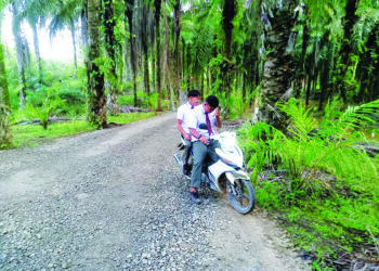 DUA calon SPM melalui jalan alternatif yang berkerikil dan berbahaya berdekatan laluan utama Jalan Jerantut-Benta yang ditutup di Kampung Jaya Putra, Jerantut, Pahang. – UTUSAN/HARIS FADILAH AHMAD