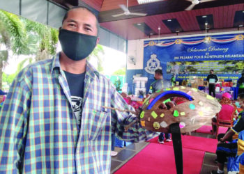 SHAHID Selamat menunjukkan helmet sabut kelapa buatan sendiri ketika menyertai program Fun Ride PDRM di IPK Kelantan, Kota Bharu, baru-baru ini. - UTUSAN/ROHANA MOHD. NAWI