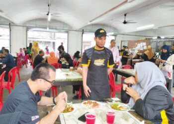 PENGURUS Besar NDAT Cawangan Bandar, Shazlan Taieffu Azlan (tengah) menyantuni pelanggan sempena program hidangan percuma di Kuala Terengganu, semalam. - UTUSAN/AKAMALIZA KAMARUDDIN
