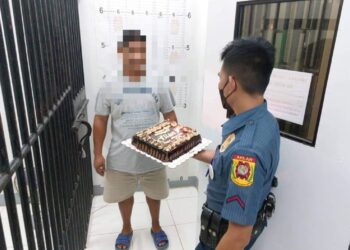 ANGGOTA polis memberikan hadiah kek sempena ulang tahun kelahiran seorang pelarian Filipina di sebuah lokap.-FB