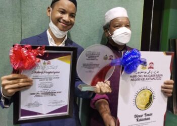 ASIF bersama bapanya Suhaimi Yunus menunjukkan anugerah diterima sempena Sambutan Hari OKU Muqarrabun Peringkat Negeri Kelantan 2022 di Putik, Pengkalan Chepa, Kota Bharu semalam. - UTUSAN/ROSALWANI CHE SOH