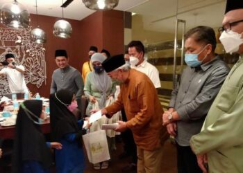 BUNG Moktar Radin (tiga kanan) menyampaikan sumbangan kepada salah seorang anak yatim di Kota Kinabalu baru-baru ini.