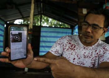 MAT Tarmizi Ahmad menunjukkan kandungan WhatsApp mengenai tahanan Rohingya mencuri pakaian di Taman Jawi Indah, Nibong Tebal, Pulau Pinang semalam. - UTUSAN/SHAHIR NOORDIN