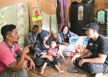 MUHAMMAD Azri Abdul Jalil (kanan) melawat keluarga Muhammad Al Idrus Mohd. Dasuki yang menghidap pelbagai jenis penyamit termasuk lelangit sumbing di Kampung Star, Gua Musang, Kelantan. - UTUSAN/AIMUNI TUAN LAH