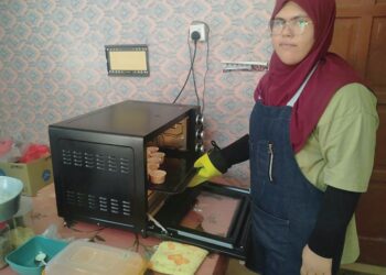 NURUL HIDAYAH Saad menunjukkan ketuhar kecil miliknya yang tidak mampu menyediakan biskut, kek dan pastri dalam jumlah yang besar berbanding permintaan cukup menggalakkan daripada pelanggan di Felda Kota Gelanggi Dua di Jerantut, Pahang. - UTUSAN/HARIS FADILAH AHMAD