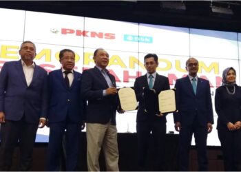 MAHMUD Abbas (kiri) dan Jay Khairil Jeremy Abdullah menunjukkan MOU yang dimeterai di Ibu pejabat PKNS, Shah Alam, Selangor, hari ini. - UTUSAN / ISKANDAR SHAH MOHAMED