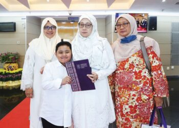 NUR Akmar Mohd. Salleh (dua dari kanan) bersama ahli keluarganya dalam Sidang Ke-4 Istiadat Konvokesyen UiTM Ke-96 bagi menerima ijazah milik arwah anaknya di Dewan Agong Tuanku Canselor di UiTM, Shah Alam, Selangor. - UTUSAN / AFIQ RAZALI