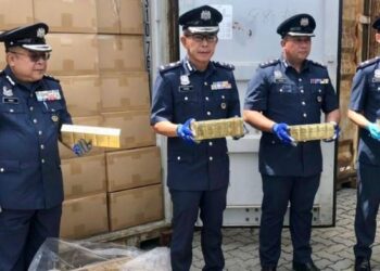 CHEONG Yu Min (dua kiri) menunjukkan rokok seludup yang dirampas di Pelabuhan Sepanggar di Kota Kinabalu hari ini.-UTUSAN/SURAIDAH ROSLAN