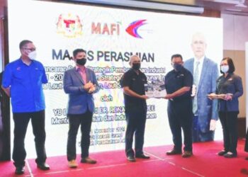 RONALD Kiandee (tengah) menyerahkan buku Pelan Strategik Pembangunan Industri Tuna dan Pelan Strategik Pembangunan Industri Tuna Laut China Selatan, Laut Sulu dan Laut Sulawesi 2021-2030 kepada Ketua Pengarah Perikanan,   Ahmad Tarmidzi Ramly (dua kanan), di Labuan hari ini.