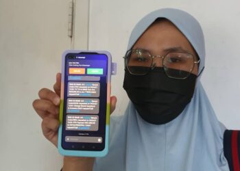 NUR Asyikin W. Azemim menunjukkan SMS yang diterima daripada individu yang menyamar sebagai wakil syarikat BigPay di Langkawi hari ini. - UTUSAN/NUR AMALINA AZMAN
