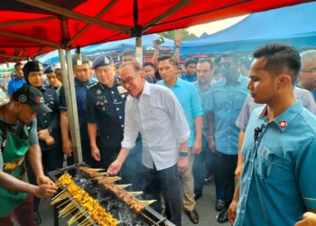 ANWAR Ibrahim membakar sate di sebuah gerai di tapak pasar malam ketika sesi ramah-mesra bersama warga Balik Pulau di pekarangan Masjid Daerah Barat Daya, Balik Pulau, Pulau Pinang hari ini.