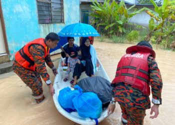 Anggota bomba menyelamatkan mangsa yang  terperangkap dalam banjir kilat yang berlaku di Kampung Mohd. Amin, Johor Bahru pagi ini.