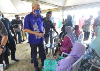 ISMAIL SABRI Yaakob (berdiri) berbual dengan mangsa banjir pada Majlis Santunan Kasih Mangsa Banjir di pekarangan Masjid Kampung Guai di Bera, Pahang. - FOTO/SHAIKH AHMAD RAZIF