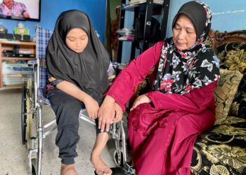 MARIAM Md. Isa menunjukkan keadaan kaki Putri Nur Damia Danisha Abdullah yang perlu dibedah dengan segera namun tertangguh kerana masalah kewangan ketika ditemui di Taman Aman, Alor Setar. 
– UTUSAN/JAMLIAH ABDULLAH