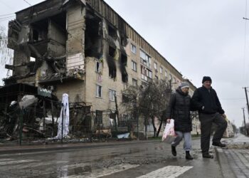 PENDUDUK berjalan melepasi sebuah bangunan kediaman yang musnah akibat pencerobohan Russia di pekan Gostomel, berhampiran Kyiv di Ukraine. - AFP