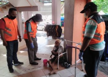 CHE Muda Ismail (bertongkat) ditahan pihak berkuasa ketika sedang mengemis di Pasar Siti Khadijah, Kota Bharu, hari ini. - UTUSAN/ROHANA MOHD. NAWI