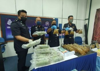 BAHARUDIN Abdullah (dua, dari kanan) menunjukkan antara bungkusan plastik dipercayai air ketum dalam sidang akhbar di Ibu Pejabat Polis Daerah (IPD) Dungun, hari ini.