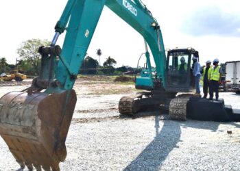 AMINUDDIN Harun menggunakan jentera penggorek sebagai gimik pelancaran projek Rumah Mampu Milik Taman Kirby dekat Labu di Seremban hari ini.-UTUSAN/NAZARUDIN SHAHARI.