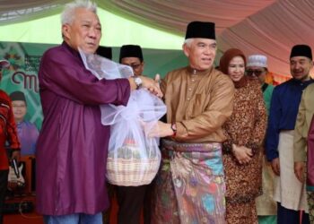 BUNG Moktar Radin (kiri) menerima cenderamata daripada Yusof Yaacob (kanan) semasa Majlis Rumah Terbuka Aidilfitri ADUN Sindumin di Sipitang semalam.