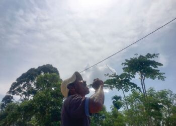 IBRAHIM Harun meneguk air untuk menghilangkan dahaga berikutan cuaca panas 'melampau' sedang melanda Kuala Krai, Kelantan ketika ini.-UTUSAN/ROSMIZAN RESDI.