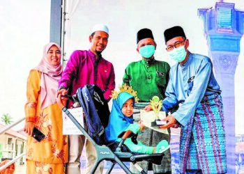 SAUFIYYAH NAAILAH Nor Akmal menerima sijil dan trofi juara hafazan ditemani ibu, Zurah Abu (kiri) dan bapa, Nor Akmal Jamil (dua dari kiri) di Baitul Tariq, Klebang Permai, Melaka. - UTUSAN/AMRAN MULUP