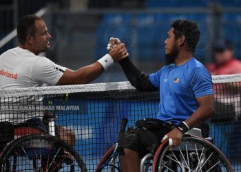 ABU SAMAH (kanan) mengucapkan syabas kepada Tom Egberink selepas pemain Belanda itu menewaskannya dengan keputusan 0-6, 1-6 pada Sukan Paralimpik 2020 di Gelanggang Tenis Ariake, kelmarin.- IHSAN MSN