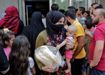 SEORANG wanita mendukung anak kecilnya yang sedang memegang sebungkus roti dari sebuah kedai bakeri di Nabaa, pinggir bandar Beirut, ditengah-tengah kekurangan barangan asas akibat krisis ekonomi di Lubnan. – AFP