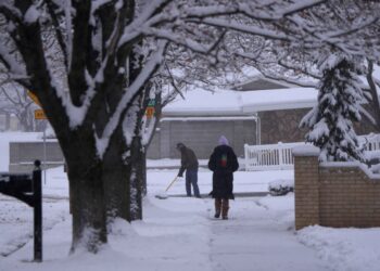 SEORANG lelaki membersihkan laluan pejalan kaki di depan rumahnya yang ditimbus salji tebal di Utah, Amerika Syarikat. - AFP