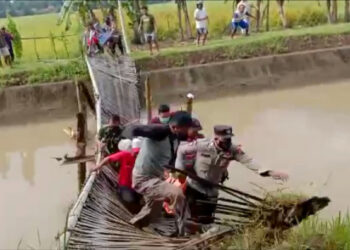 TANGKAP layar video menunjukkan penduduk dan polis yang membawa beg jenazah terjatuh ke dalam sungai akibat jambatan runtuh. - AGENSI