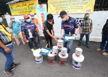DENSONNE Yap (kanan) menyerahkan cat kepada ahli jawatankuasa di pekarangan Musalla Flat Buluh Kubu, Kota Bharu, Kelantan baru-baru ini. - UTUSAN/ROHANA MOHD. NAWI